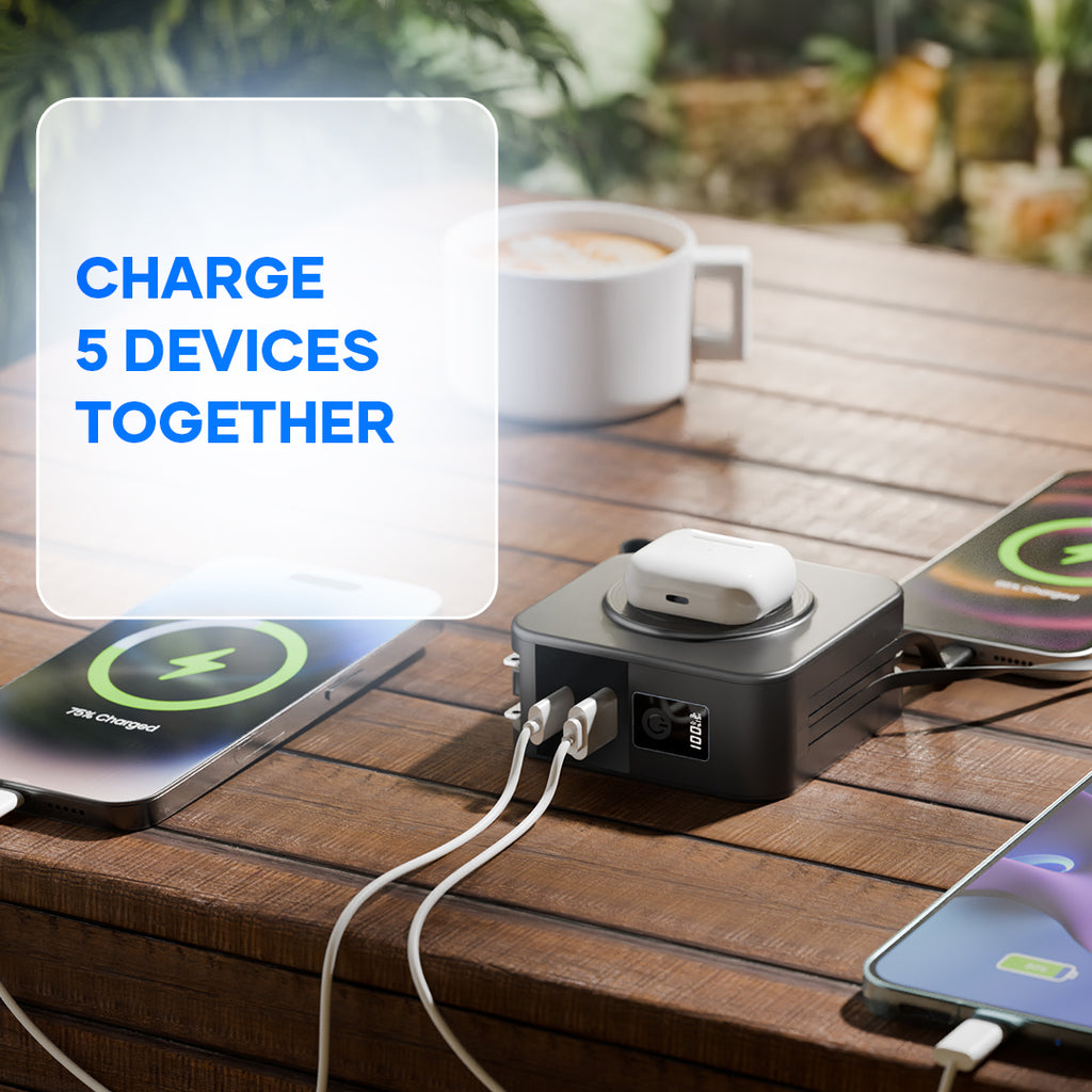 Multi-device power bank charging smartphones and earbuds on a wooden table outdoors